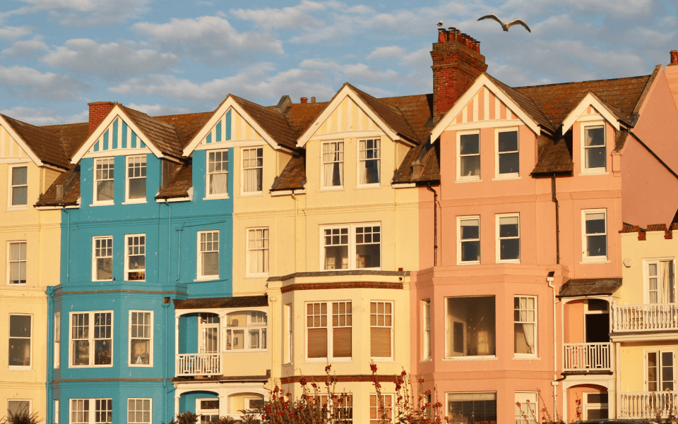 Row of colourful Victorian terraced houses under a blue sky