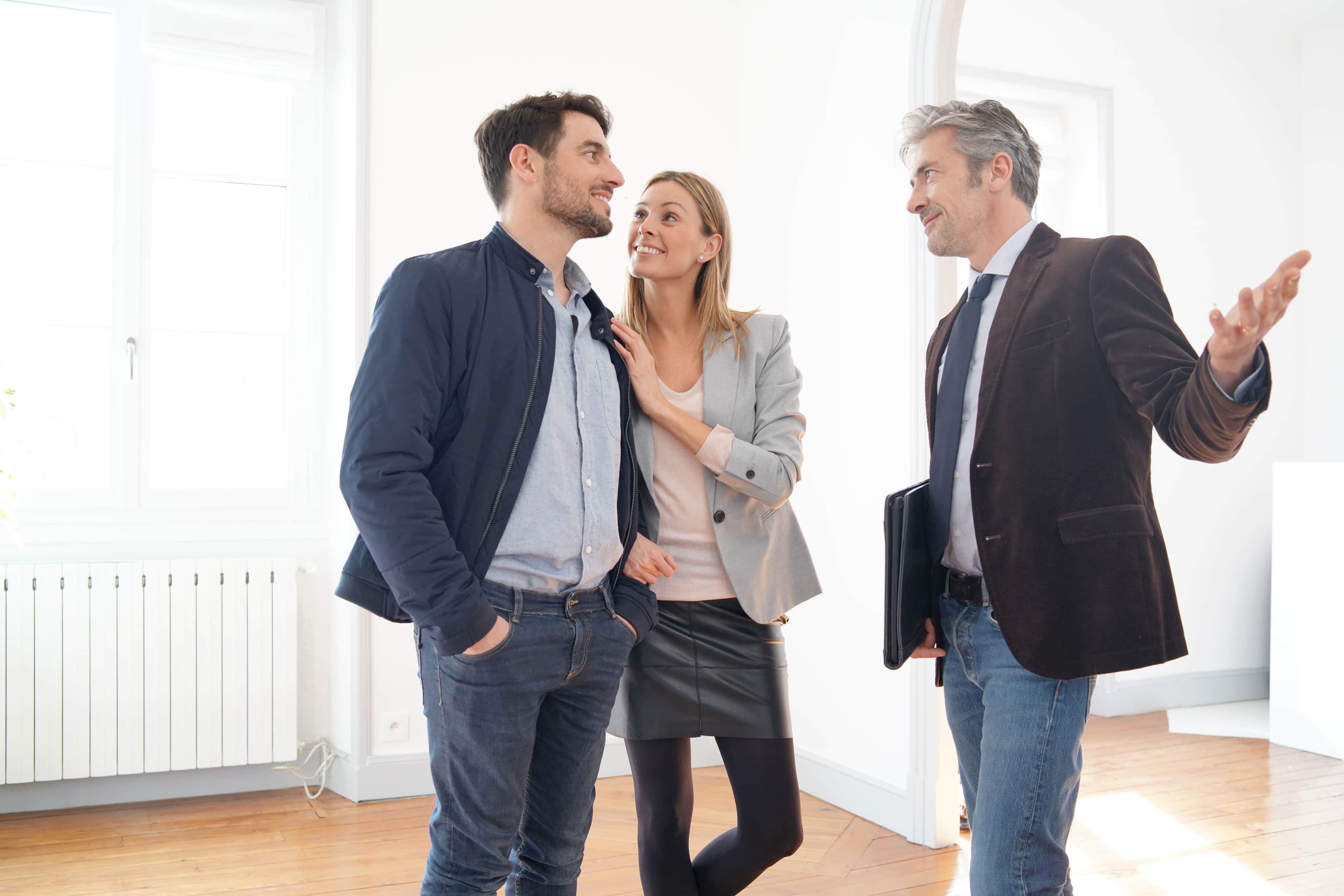 Estate agent showing a couple around an empty home